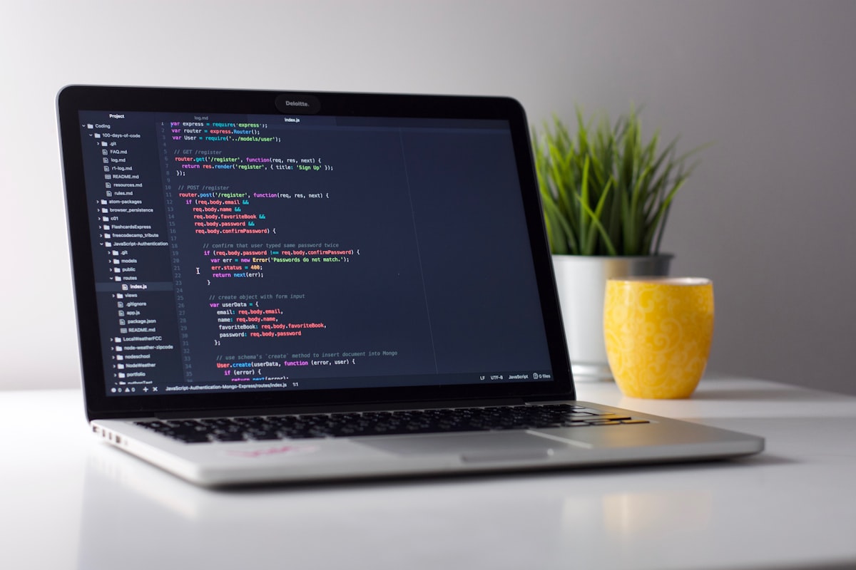 Un ordinateur portable affichant du code source, posé sur un bureau épuré